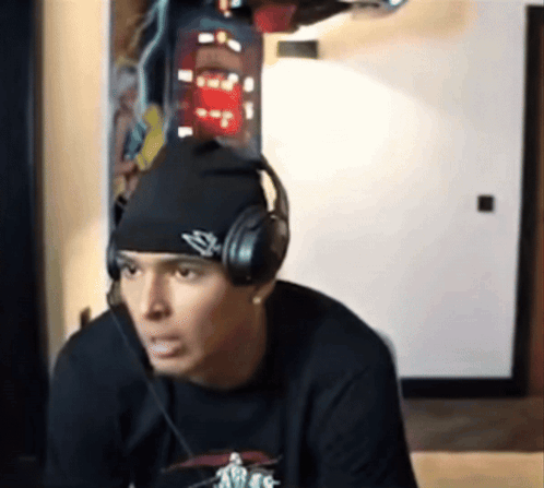 A Man Wearing Headphones And A Beanie Has The Letter S On It GIF