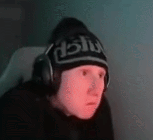 a man wearing headphones and a beanie is sitting in front of a computer .