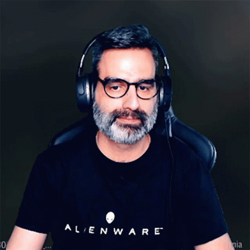 A Man Wearing Headphones And A Black Alienware Shirt GIF
