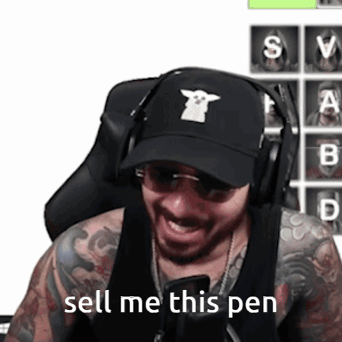 A Man Wearing Headphones And A Black Hat Says Sell Me This Pen GIF