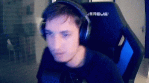 A Man Wearing Headphones And A Black Shirt Is Sitting In A Gaming Chair . GIF