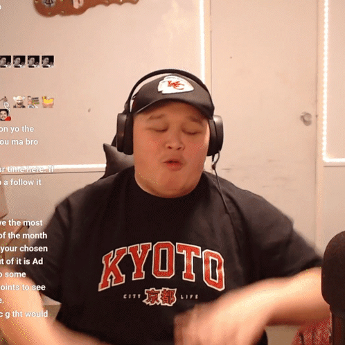 A Man Wearing Headphones And A Black Shirt That Says Kyoto On It GIF