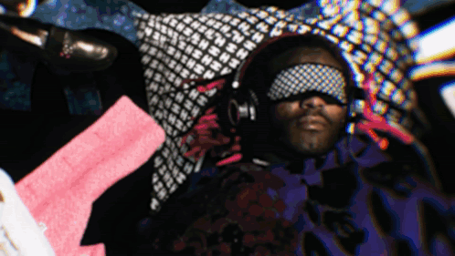 A Man Wearing Headphones And A Blindfold With The Letter N On It GIF