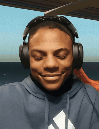 A Man Wearing Headphones And A Blue Adidas Hoodie GIF