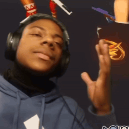 A Man Wearing Headphones And A Blue Hoodie With A White Triangle On The Front GIF