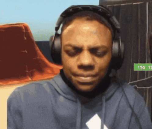 A Man Wearing Headphones And A Blue Shirt With A White Diamond On The Front GIF