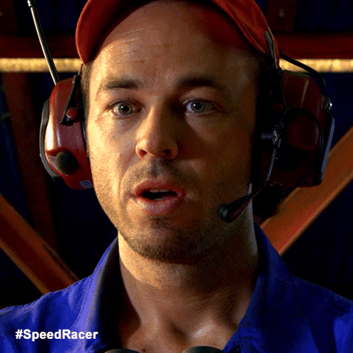 A Man Wearing Headphones And A Blue Shirt With The Hashtag #Speedracer On The Bottom GIF