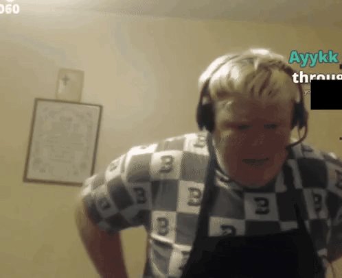 a man wearing headphones and a checkered shirt with the letters b on it