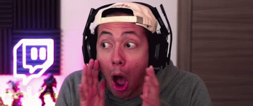 A Man Wearing Headphones And A Hat Is Making A Funny Face . GIF