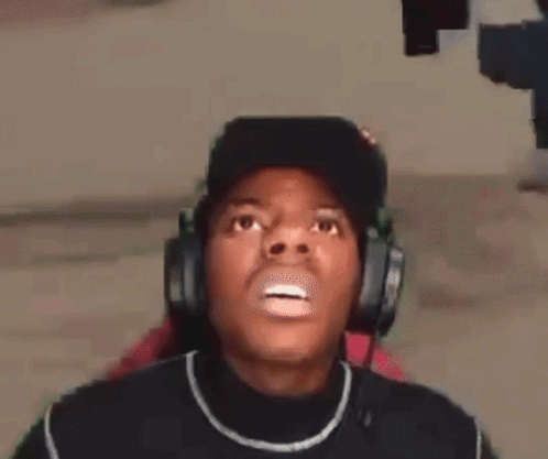 a man wearing headphones and a hat is making a surprised face .