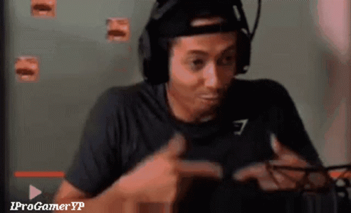 A Man Wearing Headphones And A Hat Is Playing A Video Game And Giving A Thumbs Up . GIF