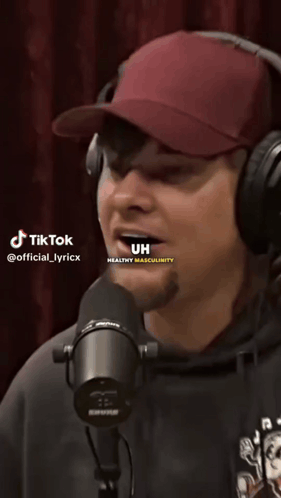 A Man Wearing Headphones And A Hat Is Singing Into A Microphone With Tiktok Written On The Bottom Of The Screen GIF