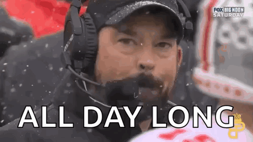 A Man Wearing Headphones And A Hat Says `` All Day Long '' During A Football Game . GIF