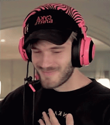 A Man Wearing Headphones And A Hat That Says Akv On It . GIF