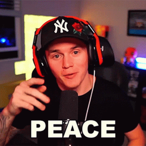 A Man Wearing Headphones And A Hat With Ny On It GIF