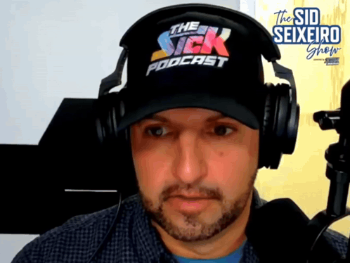 A Man Wearing Headphones And A Hat With The Sick Podcast Written On It GIF