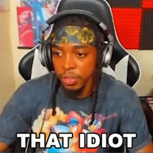 A Man Wearing Headphones And A Headband Is Sitting In A Chair With The Words `` That Idiot '' Written On His Face . GIF