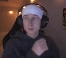 a man wearing headphones and a headband is sitting in front of a computer .
