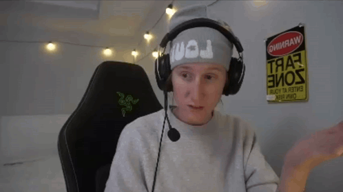 a man wearing headphones and a headband with the letter j on it sits in a chair