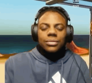 A Man Wearing Headphones And A Hoodie Is Looking At The Camera . GIF