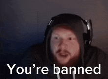 A Man Wearing Headphones And A Hoodie Is Saying You 'Re Banned . GIF