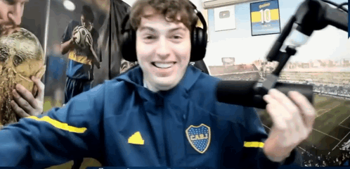 a man wearing headphones and a jacket with cabj on the front