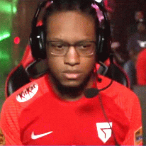A Man Wearing Headphones And A Kitkat Shirt Is Sitting In A Chair GIF