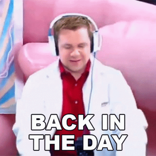 A Man Wearing Headphones And A Lab Coat Is Sitting On A Pink Couch And Saying `` Back In The Day '' . GIF