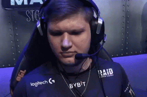 A Man Wearing Headphones And A Logitech Shirt Is Sitting In A Chair With A Microphone . GIF