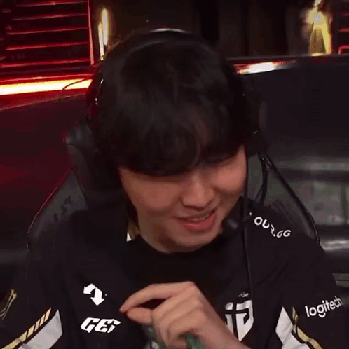 A Man Wearing Headphones And A Logitech Shirt Is Smiling GIF
