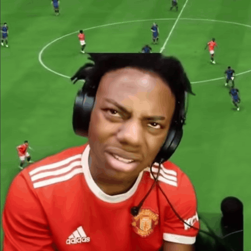 A Man Wearing Headphones And A Manchester United Shirt Is Playing A Video Game . GIF