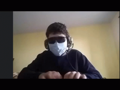 A Man Wearing Headphones And A Mask Is Looking At The Camera GIF