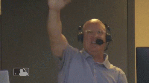 A Man Wearing Headphones And A Microphone Holds His Fist In The Air . GIF