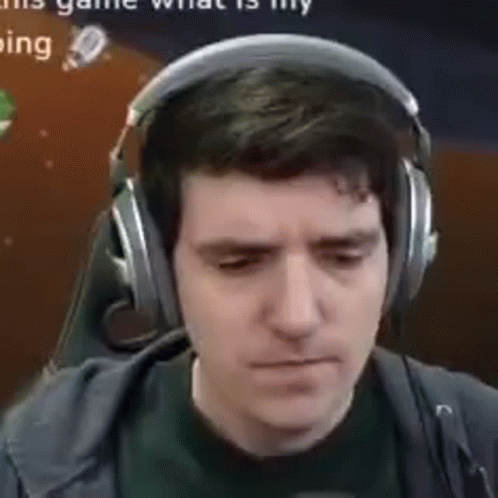 A Man Wearing Headphones And A Microphone Is Looking Down . GIF