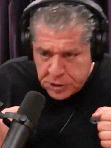 A Man Wearing Headphones And A Microphone Is Making A Funny Face . GIF