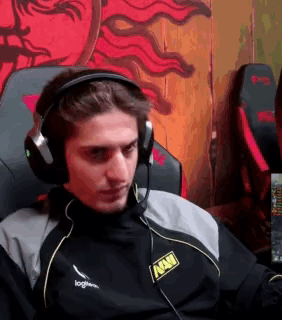 A Man Wearing Headphones And A Microphone Is Sitting In A Chair In Front Of A Computer . GIF