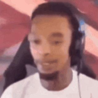 A Man Wearing Headphones And A Microphone Is Sitting In Front Of A Computer Screen . GIF