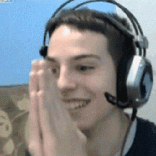 A Man Wearing Headphones And A Microphone Is Smiling And Making A Face . GIF