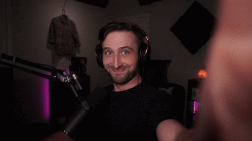 A Man Wearing Headphones And A Microphone Looks At The Camera GIF
