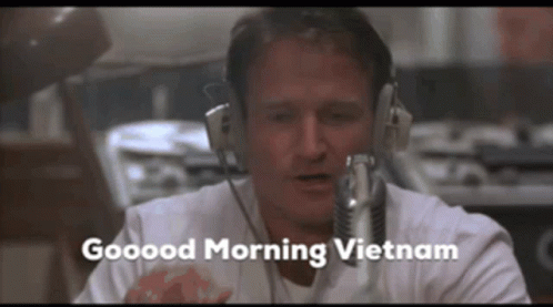 A Man Wearing Headphones And A Microphone Says Good Morning Vietnam GIF