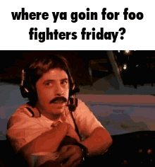 A Man Wearing Headphones And A Mustache Is Sitting In A Plane . GIF