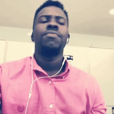 A Man Wearing Headphones And A Pink Shirt With The Letter B On The Front GIF