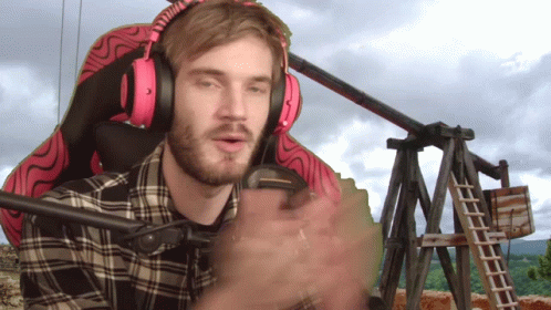A Man Wearing Headphones And A Plaid Shirt Is Sitting In A Chair GIF