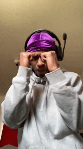 A Man Wearing Headphones And A Purple Headband Covering His Eyes GIF