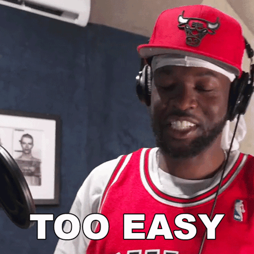 A Man Wearing Headphones And A Red Bulls Hat Says " Too Easy " GIF