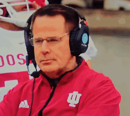 A Man Wearing Headphones And A Red Jacket With The Word Adidas On It GIF