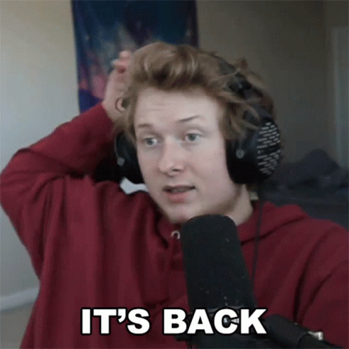 A Man Wearing Headphones And A Red Shirt Says It 'S Back In Front Of A Microphone GIF