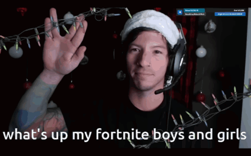A Man Wearing Headphones And A Santa Hat With The Words What 'S Up My Fortnite Boys And Girls Below Him GIF
