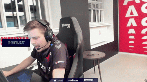 A Man Wearing Headphones And A Shirt That Says Money Is Sitting In A Chair GIF