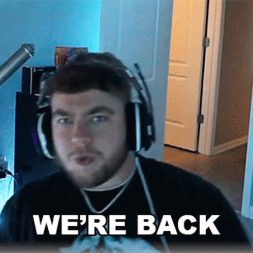 A Man Wearing Headphones And A Shirt That Says We 'Re Back . GIF